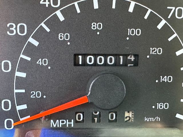 Dashboard showing speedometer with 0 mph, odometer reading 100014, and trip/secondary digits; Ford F550 listing with fire truck context.