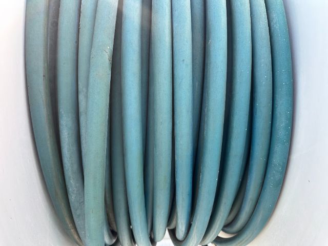 Coiled blue hose or cable wound in multiple loops.
