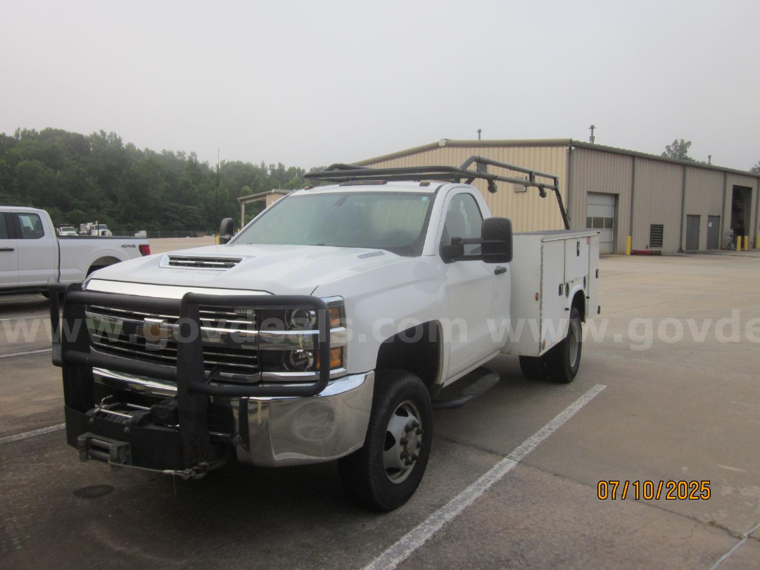 White 2017 Chevrolet Silverado 3500HD service/utility truck with front brush guard and utility bed parked in lot.