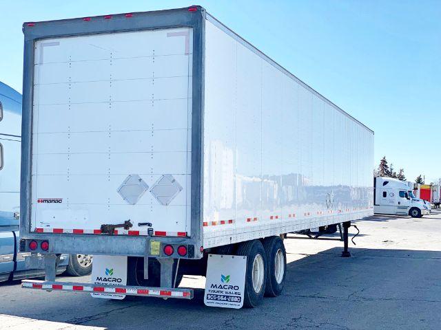 Manac 2015 dry van trailer rear and side view showing white enclosed box with rear doors and dual rear axles.