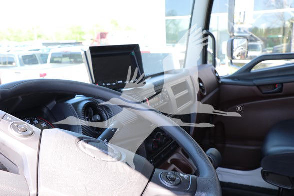 Cab interior of a 2025 Hino L6 truck showing steering wheel, dashboard, and a mounted screen in the center.