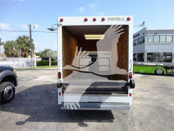 Ford E-350 box truck rear with open cargo area, ramp down, cargo interior visible.