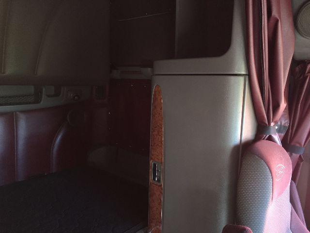 Peterbilt 578 truck interior/closer view showing cabin area with wood trim and seatbelt, part of dashboard and sleeper cab.
