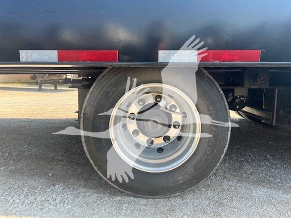 Trailer wheel and fender with dual-axle, steel wheel, tire, and reflective tape. Visible text may be on VIN/stock but not legible in image.
