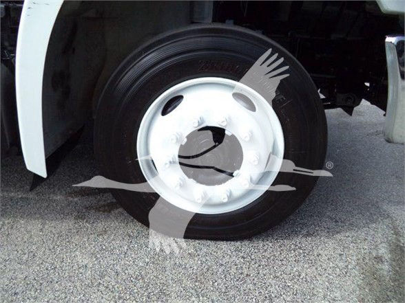 Truck wheel and tire on a Hino 258LP hooklift truck showing a white steel wheel and tire with valve stem.