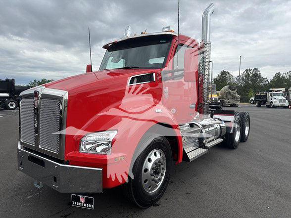 Kenworth T880 2026 conventional daycab truck in red, front and side view showing chrome grille, headlights, side mirrors, dual exhaust stacks, and aluminum steps.
