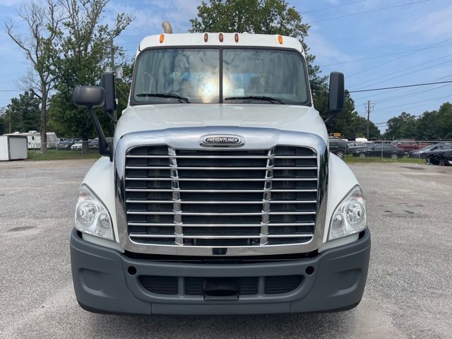 Front view of a white 2013 Freightliner Cascadia heavy-duty truck with large chrome grille, dual headlights, and gray front bumper.