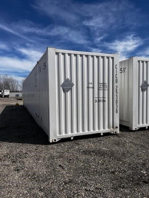 53' CIMC intermodal dry container with vertical corrugated metal walls, white color, stock numbers printed on doors. Side text includes weight and identification markings.