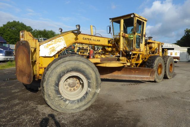 1940s Caterpillar 16G motor grader in service condition with yellow paint and large front moldboard, two rear axles, and operator cab