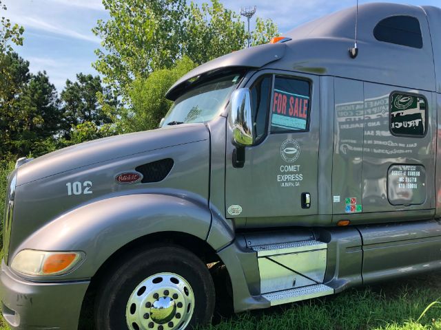 Peterbilt 387 truck cab side view with 'FOR SALE' sign on window, number 102 on fender, Comet Express logo, and aluminum step with tread plate.