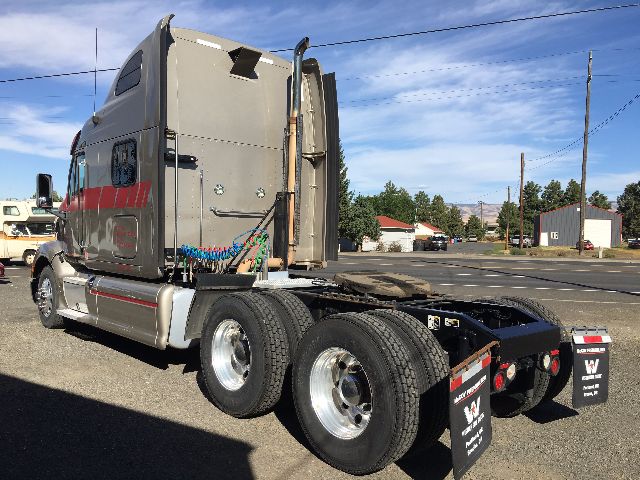 Peterbilt 578 sleeper cab tractor from rear-left side showing dual rear axles and fifth wheel; gray exterior with red reflective tape; stock number 72337; VIN partially visible.