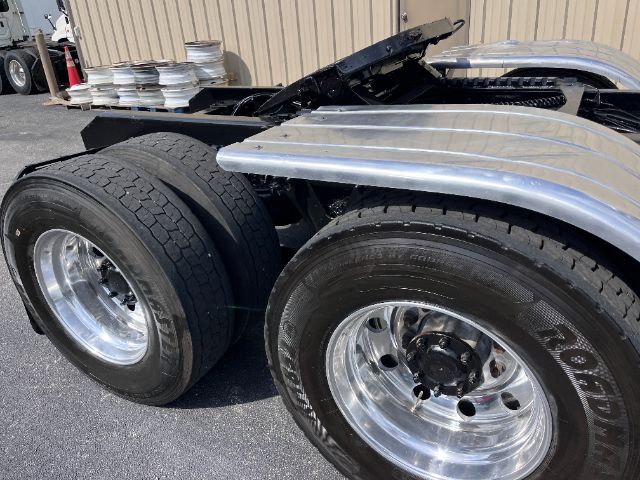 2014 Kenworth T800 dual rear wheel tractor with polished chrome wheels and aluminum fenders visible.
