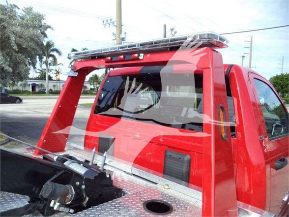 Ram 4500 truck with red cab and service bed, tow equipment visible, back window and roof light bar.