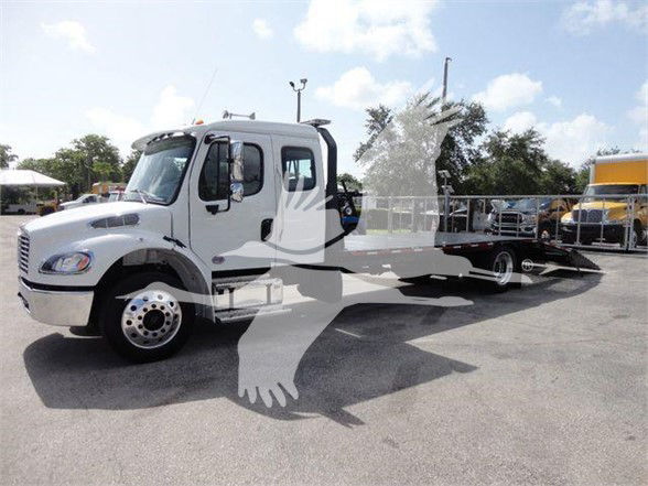 Fleet truck: 2023 Freightliner BUSINESS CLASS M2 106 tow truck with a lowbed trailer attached in a dealership lot.
