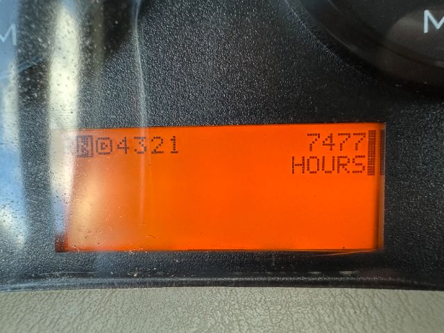 Instrument display shows hours and odometer digits: 04321 and 7477? hours? The orange LCD with black digits; part of International 7500 vacuum truck gauge cluster.