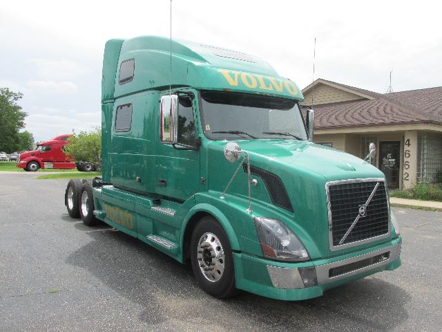 Volvo 780 conventional sleeper truck in green with yellow Volvo lettering on cab and chrome grille.