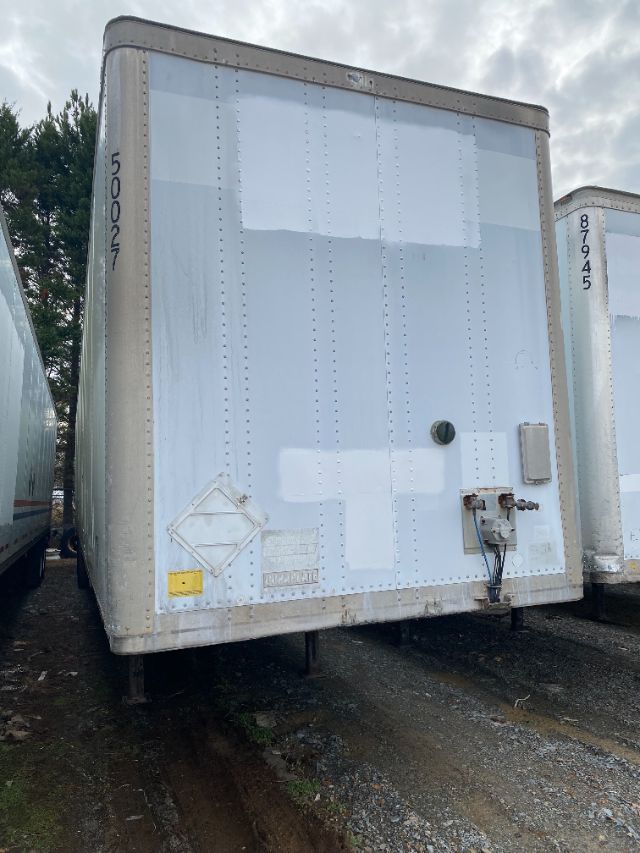 Trailer rear door with Wabash Duraplate, vertical riveted panels, rear utility box, and electrical connections. Vehicle identification numbers painted on sides.