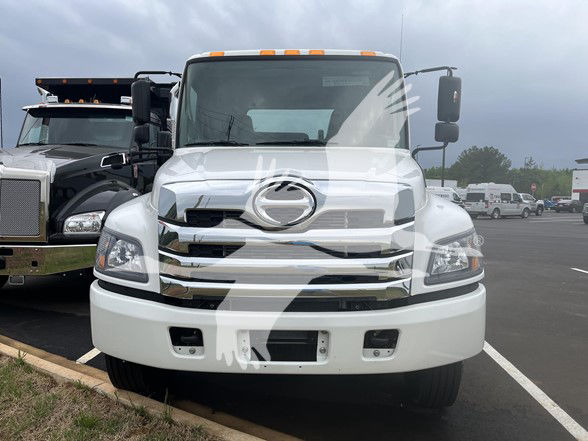 Front view of a white 2026 Hino L6 cab and chassis truck with chrome grille, large bumper, and side mirrors.