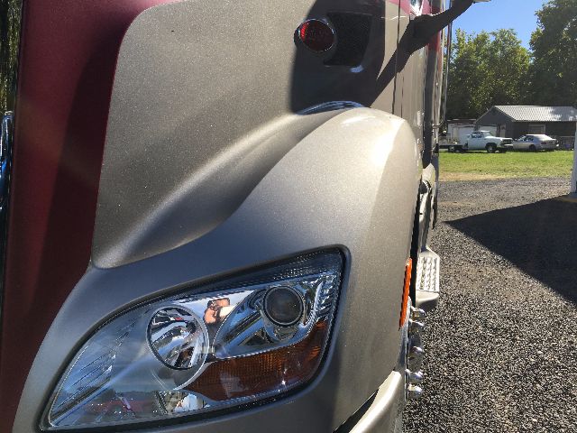 Peterbilt 578 truck front corner showing headlight assembly and silver exterior