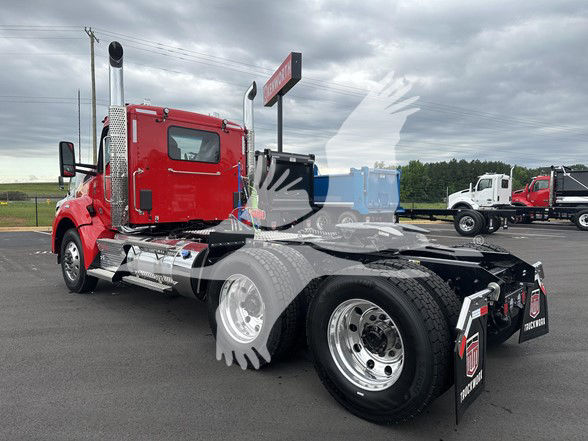 Kenworth T880 chassis cab with red cab, chrome exhaust stacks, and black rear chassis showing fifth wheel and dual rear wheels.