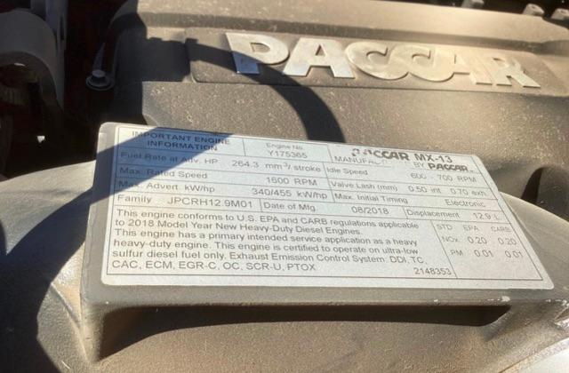 Engine cover badge with engine specs and EPA information plate for a Peterbilt. Includes fuel rate, horsepower, torque, RPM, and model year details.