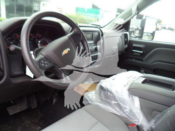 Chevrolet Silverado 6500HD interior dashboard and steering wheel with plastic seat covering.