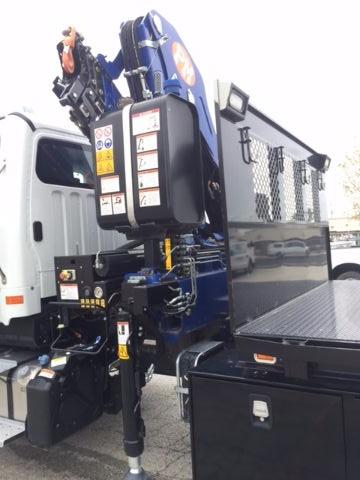 Freightliner 108SD crane cab mounted knuckle boom with warning labels, hydraulic controls, and a control panel visible.