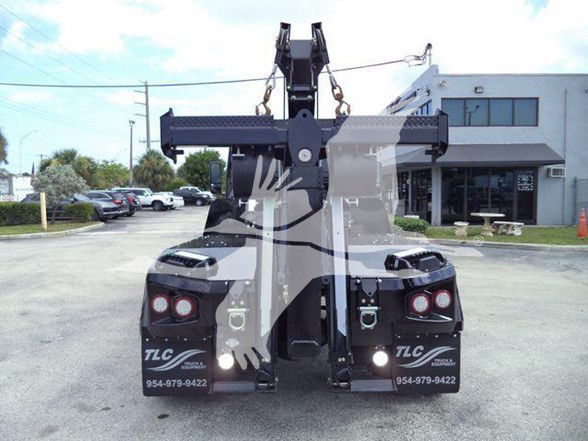 Tow truck with rear view showing lifting mechanism and TLC Mobile Equipment branding on fenders, tail lights, and contact numbers.