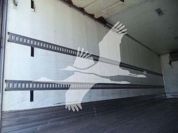 Trailer interior showing empty reefer cargo area with vertical E-track rails along the wall.