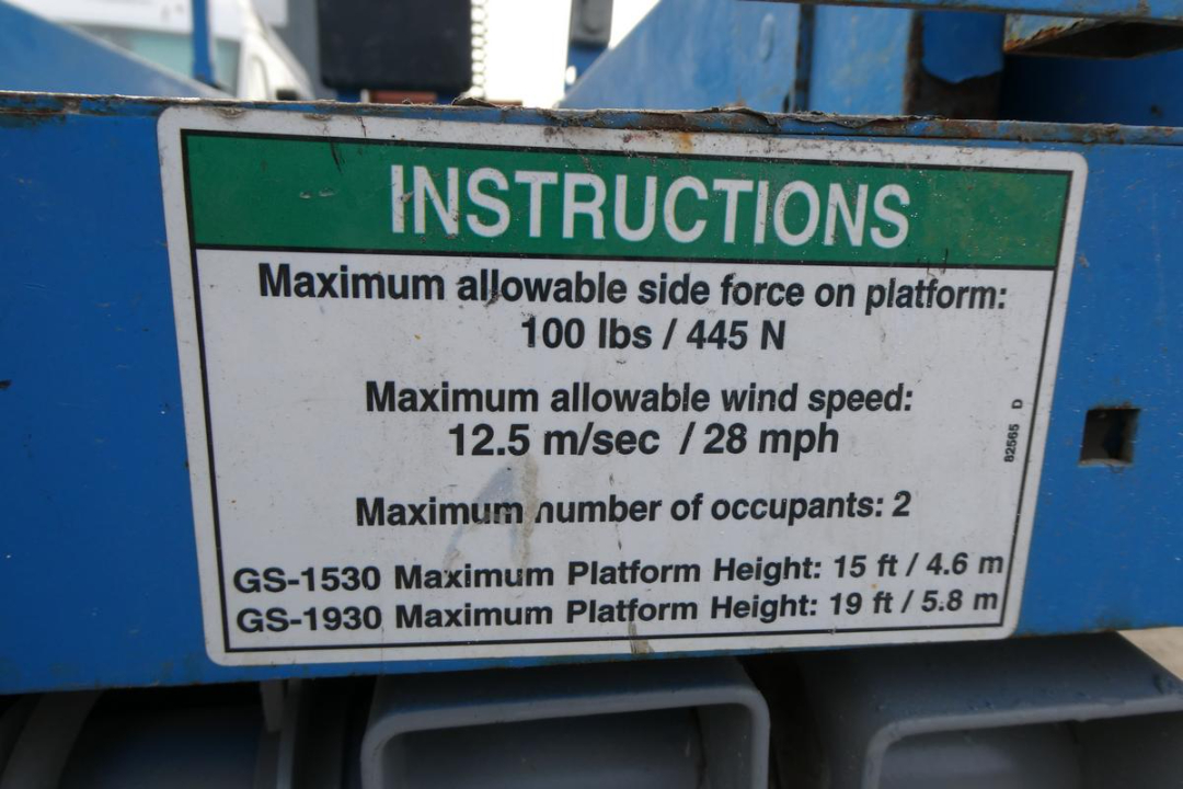 Instructions placard on Genie GS1930 platform showing maximum side force, wind speed, occupants, and platform heights.