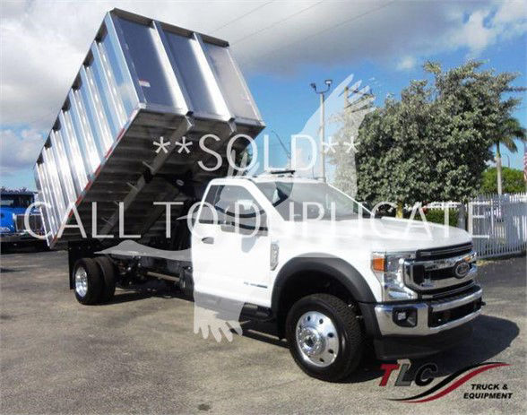 truck with a raised dump bed on a white Ford F-550 chassis