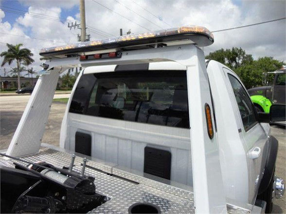 Ram 4500 SLT pickup with flatbed and utility rack, visible rear cab window and cargo area accessories.