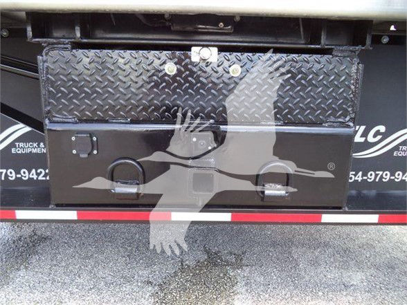 Chevrolet Silverado 6500HD dump truck tailgate area with diamond plate toolbox and black metal toolbox, reflective stripe at bumper.