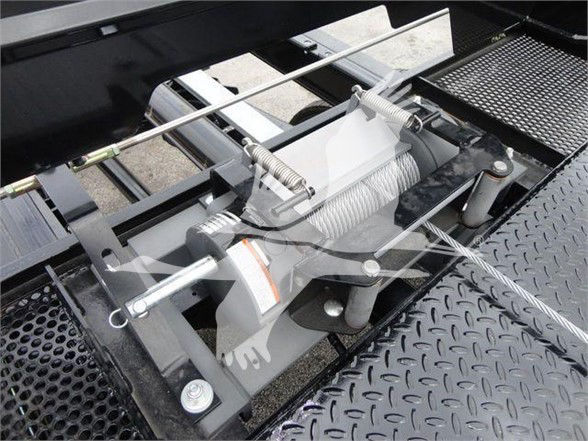 Tow truck winch assembly with steel cable, roller fairlead, and hydraulic drum mounted on a diamond plate platform.