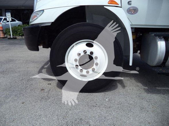 Wheel of a white International DURASTAR 4300 truck with black tire and white rim, partial fender and fuel tank visible.