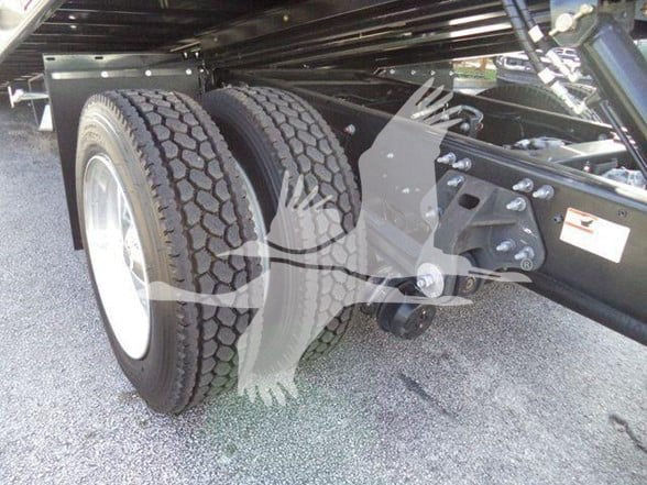 Front dual rear axle area of a new 2025 Hino 268A tow truck showing dual rear wheels and frame components.