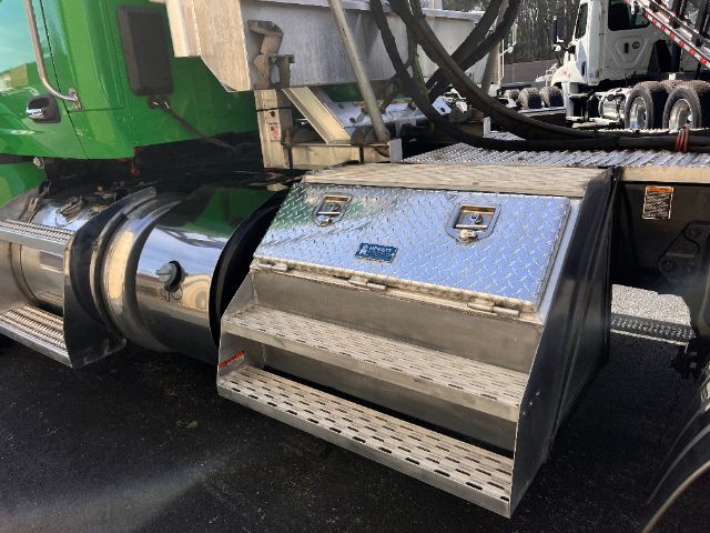 Peterbilt 579 daycab fuel/utility toolbox with diamond plate and chrome fuel tanks visible under green cab.