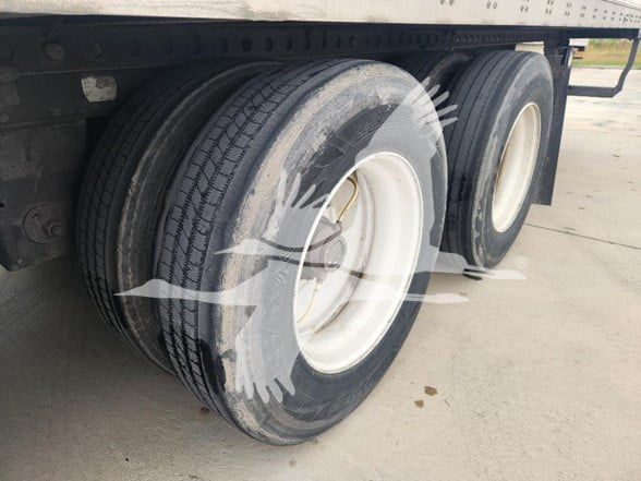 Wabash trailer wheel configuration showing dual rear axles with two tires each. Visible white rims and black tires with tread.