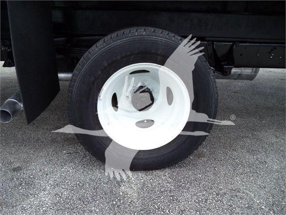 Vehicle wheel and tire on a Ford E-Series box truck, partial undercarriage visible.