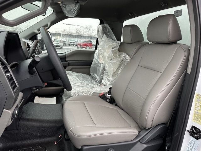 Ford F-550 interior front seats with plastic protective covers, gray leather seats, steering wheel, dashboard, driver seat with headrest