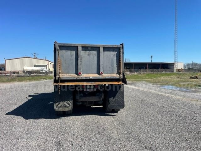 Dump truck bed of a 2012 Peterbilt 365 viewed from rear showing dump trailer, taillights, and mud flaps.