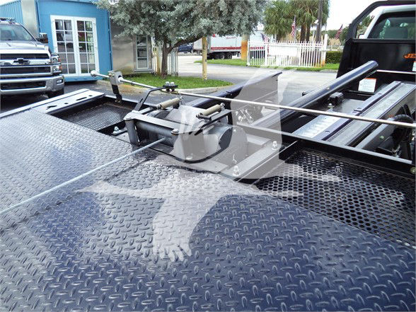 Truck bed with towing apparatus and diamond plate surface, header shows equipment mount and securing bar.