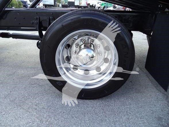 Wheel and tire on a heavy truck chassis with chrome rim and black tire, undercarriage visible.
