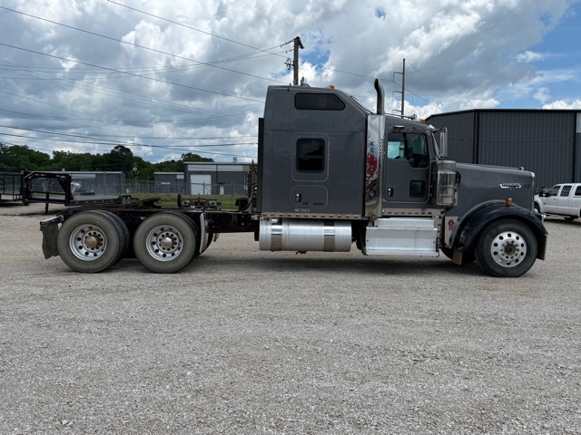 2012 Kenworth W900 conventional sleeper truck with dual rear axles and a side profile showing the cab and fuel tanks.