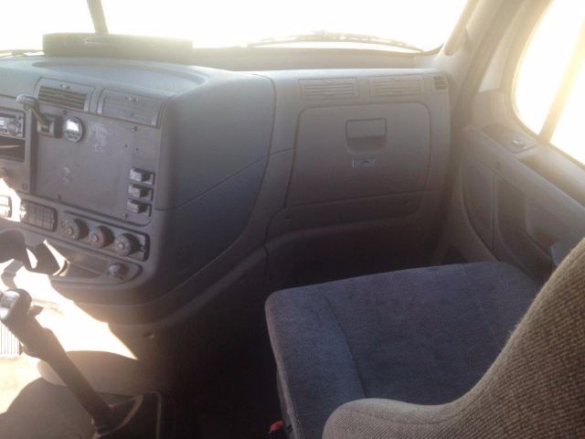 Cab interior of a 2012 Freightliner Cascadia truck showing dashboard controls and front passenger seat.