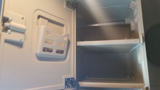 Cabinet-style storage compartments inside Freightliner Coronado 132 truck sleeper area showing shelves and interior panels.