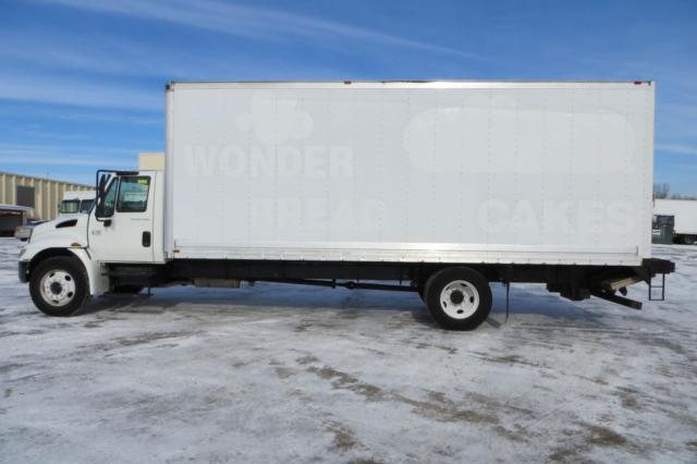 Box truck side view showing white 2003 International 4300 with HD box and cab in engine bay.