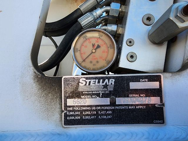 Stellar hydraulic gauge assembly with a pressure gauge and a black label plate reading 'STELLAR' with model/serial fields visible.