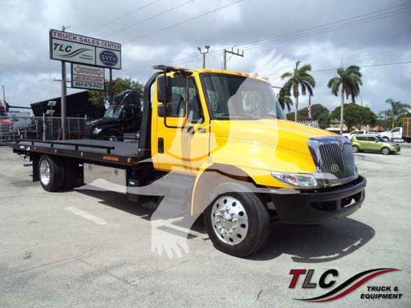 2019 International DURASTAR 4300 tow truck yellow cab with flatbed in lot, TLC Truck & Equipment logo in corner, VIN 1HTMMMML4KH512255