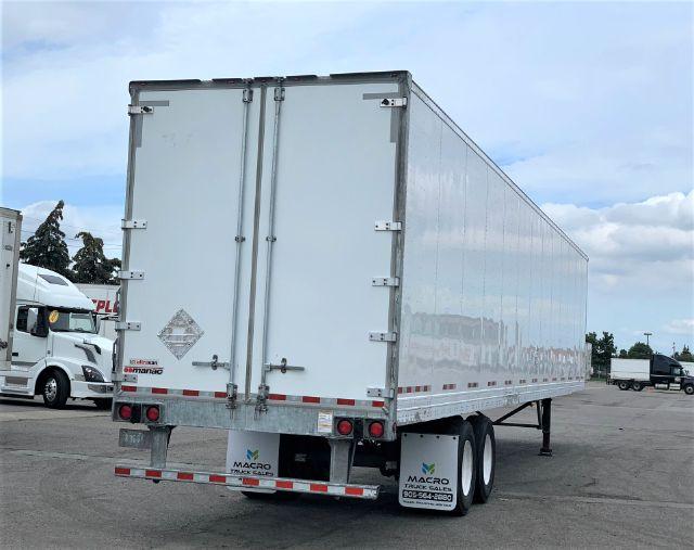 Manac dry van trailer rear view showing dual rear doors and reflective tape along lower edge.
